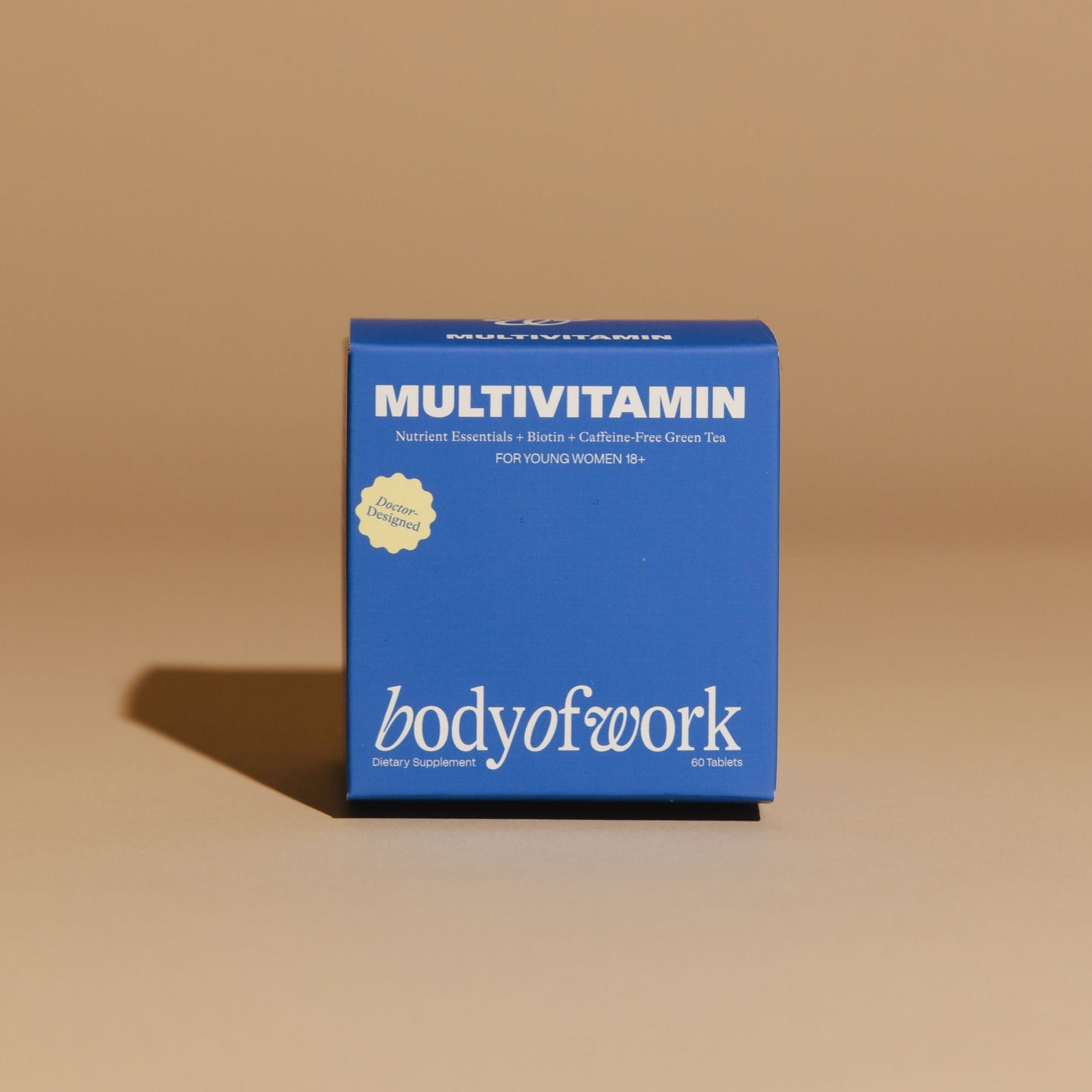Blue 'bodyofwork' multivitamin box on a beige background
